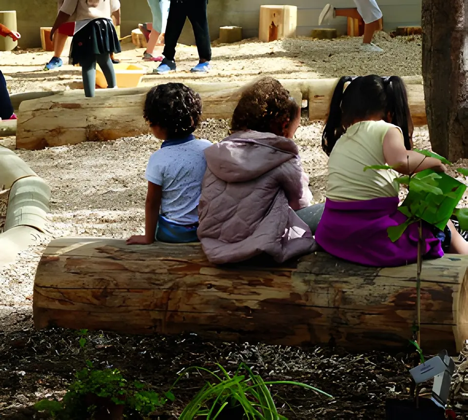 Kinderen zitten samen op een boomstam